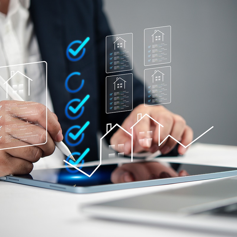 Professionnel validant une liste de contrôle numérique immobilière sur tablette. Cinq coches bleues et des fiches de propriété en réalité augmentée.